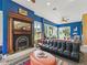 Cozy living room with a decorative fireplace, large windows, and a stylish black leather sofa at 402 Sw 127Th Pl, Ocala, FL 34473