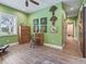 Bright home office space boasts hardwood floors, a ceiling fan and stylish decor on green walls at 402 Sw 127Th Pl, Ocala, FL 34473