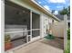 Enclosed patio area with sliding screen doors leading to the outdoor shower and well-maintained yard at 402 Sw 127Th Pl, Ocala, FL 34473