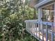 Balcony view with a white railing overlooking lush greenery, and sliding glass door at 4305 Sw 20Th Ave, Ocala, FL 34471