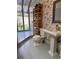 Charming bathroom featuring a unique pedestal sink, toilet, and a built-in shelving unit for storage at 4305 Sw 20Th Ave, Ocala, FL 34471