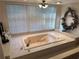 Large soaking tub surrounded by marble, with a big window overlooking the beautiful outdoors at 4305 Sw 20Th Ave, Ocala, FL 34471