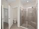 Bathroom with glass enclosed shower, toilet, and white doors that lead to other rooms at 4892 Nw 39Th Loop, Ocala, FL 34482