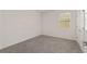 Bedroom with neutral carpeting, a window with blinds, and a white door at 4892 Nw 39Th Loop, Ocala, FL 34482