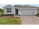 A lovely home featuring a gray exterior and a brick driveway at 4892 Nw 39Th Loop, Ocala, FL 34482