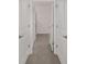 Hallway featuring neutral tile flooring with white paneled doors and chrome hardware at 4892 Nw 39Th Loop, Ocala, FL 34482