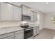 Kitchen features granite countertops, stainless steel appliances, light gray cabinets, and tile flooring at 4892 Nw 39Th Loop, Ocala, FL 34482