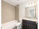 Bathroom featuring a tiled shower-tub, granite vanity, and dark wood cabinetry, providing a modern and relaxing space at 5425 Pecan Rd, Ocala, FL 34472