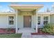 Inviting entryway featuring a covered porch with a neutral color scheme, clean lines and tasteful landscaping at 5425 Pecan Rd, Ocala, FL 34472