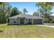 Well-maintained single-story home with a two-car garage and front lawn surrounded by mature trees at 5425 Pecan Rd, Ocala, FL 34472