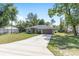 Charming single-story home with an expansive front lawn, long driveway, and attached two-car garage at 5425 Pecan Rd, Ocala, FL 34472
