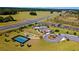 Aerial view featuring community amenities including a pool, sports courts, and clubhouse set in lush landscape at 6265 Sw 88Th Loop, Ocala, FL 34476