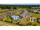 An aerial view of a community pool, amenity center, bocce ball court and tennis court surrounded by trees and homes at 6265 Sw 88Th Loop, Ocala, FL 34476