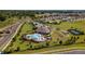 Aerial view of community pool, clubhouse, bocce ball and tennis courts surrounded by green landscaping and homes at 6265 Sw 88Th Loop, Ocala, FL 34476