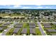 An aerial view shows rows of homes in a well-maintained neighborhood with mature trees and open green spaces at 6265 Sw 88Th Loop, Ocala, FL 34476
