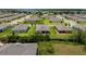 An aerial view showcasing backyard with green lawns and landscaping in a suburban neighborhood at 6265 Sw 88Th Loop, Ocala, FL 34476