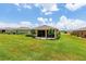 Spacious backyard showcasing the home's exterior with a screened in patio at 6265 Sw 88Th Loop, Ocala, FL 34476