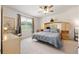 Cozy bedroom featuring plush carpet, a ceiling fan, and a window with a view to the outdoors at 6265 Sw 88Th Loop, Ocala, FL 34476