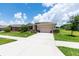 Inviting single-story home featuring a spacious driveway, manicured lawn, and colorful landscaping at 6265 Sw 88Th Loop, Ocala, FL 34476