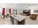 Open kitchen area with island seating, dark cabinetry, and modern lighting at 6265 Sw 88Th Loop, Ocala, FL 34476