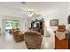 Cozy living room with comfortable seating, ceiling fan, tile flooring, and backyard access at 6265 Sw 88Th Loop, Ocala, FL 34476