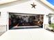 Large garage with a motorcycle parked inside and walls decorated with memorabilia at 6312 Sw 60Th Ct, Ocala, FL 34474