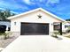 Oversized garage featuring a screened-in door, white siding and nicely landscaped entry at 6312 Sw 60Th Ct, Ocala, FL 34474