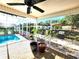 Enclosed patio with a swimming pool, brick pavers, and an outdoor grilling area beyond the screen at 6312 Sw 60Th Ct, Ocala, FL 34474