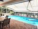 Inviting screened pool with a covered patio, brick flooring, and retractable awning for outdoor comfort and enjoyment at 6312 Sw 60Th Ct, Ocala, FL 34474