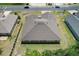 An aerial view shows the roofline and backyard with a covered patio, and a grassy lawn at 6680 Sw 179Th Court Rd, Dunnellon, FL 34432