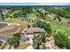 Expansive aerial of golf course community featuring a luxurious clubhouse, ponds, and lush landscaping at 6680 Sw 179Th Court Rd, Dunnellon, FL 34432