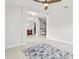 Modern tiled bedroom featuring two windows, unique ceiling fan and neutral tones at 6680 Sw 179Th Court Rd, Dunnellon, FL 34432