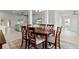 Bright dining room area with a dark wood table and decorative rug extending into the living room at 6680 Sw 179Th Court Rd, Dunnellon, FL 34432