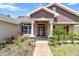 Detailed front entrance with decorative columns, stained-glass door, and manicured landscaping at 6680 Sw 179Th Court Rd, Dunnellon, FL 34432
