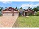 Charming single-story home with a three-car garage, beautiful landscaping, and a brick-paved driveway at 6680 Sw 179Th Court Rd, Dunnellon, FL 34432
