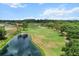 A serene view of a meticulously manicured golf course with lush green grass and a tranquil pond at 6680 Sw 179Th Court Rd, Dunnellon, FL 34432