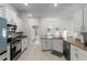 Spacious open kitchen with stainless steel appliances, white cabinets, and granite countertops at 6680 Sw 179Th Court Rd, Dunnellon, FL 34432