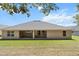 A home's rear exterior view shows a covered patio and a well maintained grassy yard at 6680 Sw 179Th Court Rd, Dunnellon, FL 34432