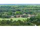 An expansive aerial view of lush green forested landscape encompassing the multi-building property at 688 Midway Dr # B, Ocala, FL 34472
