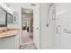 Bright bathroom featuring a shower with glass shelves, granite counters, and decorative touches at 688 Midway Dr # B, Ocala, FL 34472
