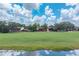 Scenic exterior view of townhomes on a golf course with lush green fairways and mature trees under a bright, cloudy sky at 688 Midway Dr # B, Ocala, FL 34472
