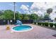 A community hot tub sits within a brick patio and surrounded by trees and green space at 688 Midway Dr # B, Ocala, FL 34472