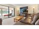 Cozy living room with a plush leather sofa, large television, and sunroom access at 688 Midway Dr # B, Ocala, FL 34472