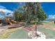 Community playground with slides and climbing structures with mature trees and a view of the adjacent lake at 688 Midway Dr # B, Ocala, FL 34472