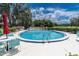 Community pool with lounge seating, umbrellas, and beautiful views of mature trees and the bright blue sky at 688 Midway Dr # B, Ocala, FL 34472