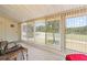 Enclosed sun room with vertical blinds showcasing views of the golf course and the lake at 688 Midway Dr # B, Ocala, FL 34472