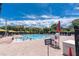 Community swimming pool area featuring a lifeguard stand, sun umbrellas, and lounge chairs at 688 Midway Dr # B, Ocala, FL 34472