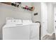 Laundry room with white appliances, overhead shelving and gray walls at 7 Pecan Drive Ter, Ocala, FL 34472