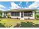 Back exterior with a screened-in porch, mulch beds, and well-maintained lawn in a private backyard at 7263 Sw 99Th Cir, Ocala, FL 34481