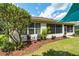 Back exterior showcasing a screened porch, landscaping with mulch beds, and a patio seating area at 7263 Sw 99Th Cir, Ocala, FL 34481